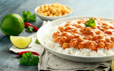Spicy chickpeas curry with rice, tomato and Poppadoms in white plate. Healthy tasty vegetarian food