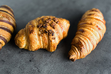 Photograph of three different kinds of traditional croissants recently baked, a delicious snack.