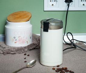 Electric coffee grinder for grinding coffee beans on the kitchen table. Appliances