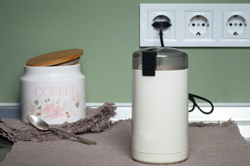 Electric coffee grinder for grinding coffee beans on the kitchen table. Appliances