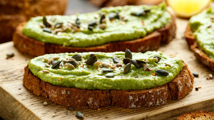 Healthy Homemade Avocado creamy Toast with nuts mix on wooden board
