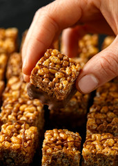 Crispy rice bar, snack with caramel and chocolate on rustic background