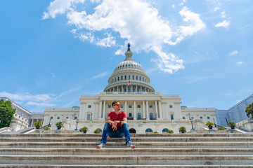 Young man sitting on the stairs by the United States Capitol in Washington.