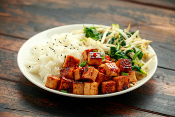Fried Asian tofu in sweet chilli glaze served with rice, steamed spinach and beansprouts. Vegetable healthy food