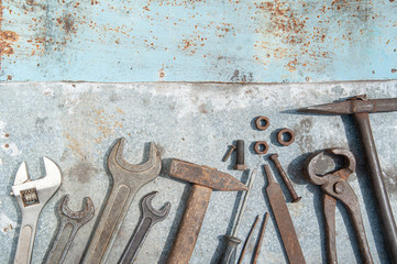 a diverse selection of rusty tools for work are unlikely to be on the metal background. Iron hammer, wrenches, screwdrivers, bolts, nuts, nails