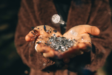 Hands of a young woman holding silver glitter