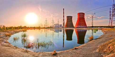 Sunset over the power plant. Power plant reflection in water. 