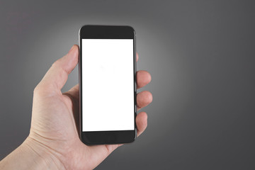 Man hand hold smartphone on gray background. Copy space