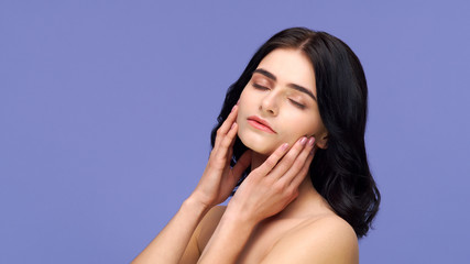 Fototapeta premium Studio portrait of young and beautiful brunette woman over background. Skin care, health, makeup and cosmetics.