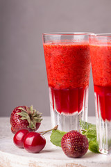 Summer blended strawberry  smoothie juice in glasses on gray background. Healthy eating diet...