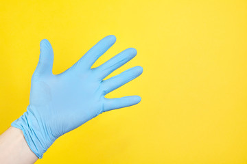 Doctor hand glove shows number five front on yellow background.