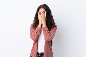 Spanish Chinese woman over isolated white background covering eyes and looking through fingers
