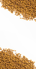 Above or Top view of animal food. Brown Dried dog food on white background. Grain pet food banner background with copy space for text design.