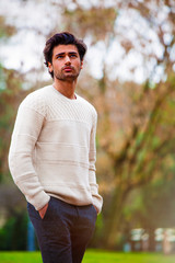 Handsome young man outdoor in the street with hands in the pockets. Fashion hairstyle, confident...