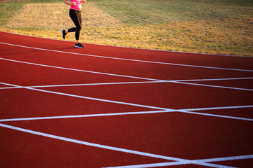 A runner on a tartan running track runs to keep himself vital