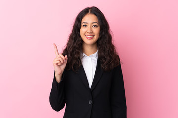 Mixed race business woman over isolated pink background pointing with the index finger a great idea