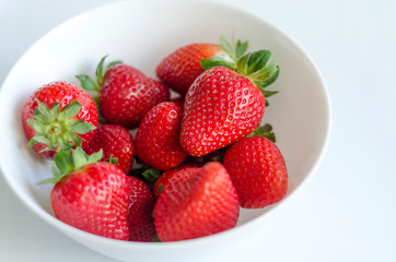 Fresh strawberries in a bowl, white background