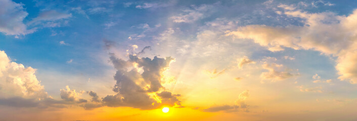 Sky blue and orange light of the sun through the clouds in the sky