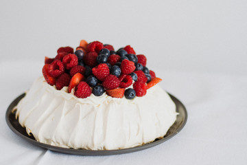 Tasty summer berry baiser pavlova cake with strawberries, raspberries and blueberries