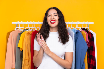 Mixed race woman in a clothing store applauding