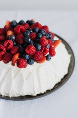 Tasty summer berry baiser pavlova cake with strawberries, raspberries and blueberries