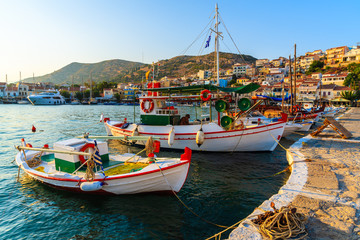 Beautiful traditional fishing boats in Pythagorion port at sunset time, Samos island, Greece