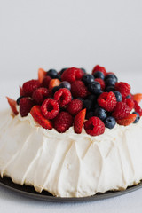 Tasty summer berry baiser pavlova cake with strawberries, raspberries and blueberries