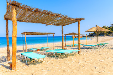 Sunbeds on Potami beach and blue sea, Samos island, Greece