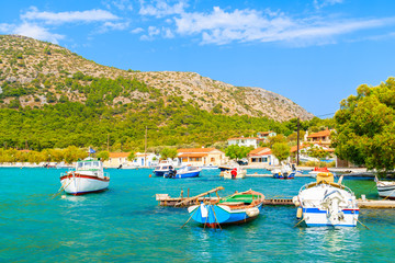 Fototapeta na wymiar Colourful Greek fishing boats on turquoise sea in Posidonio bay, Samos island, Greece