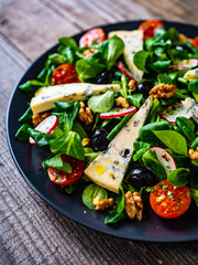 Fresh salad - blue cheese and vegetables on wooden table