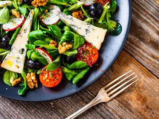 Fresh salad - blue cheese and vegetables on wooden table