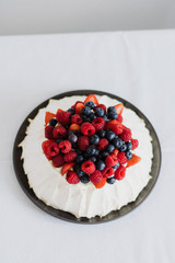 Tasty summer berry baiser pavlova cake with strawberries, raspberries and blueberries