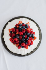 Tasty summer berry baiser pavlova cake with strawberries, raspberries and blueberries