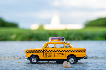 Yellow taxi model in Washington city with Washington Capitol in the background.
