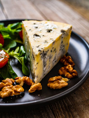 Fresh salad - blue cheese and vegetables on wooden table