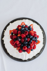 Tasty summer berry baiser pavlova cake with strawberries, raspberries and blueberries