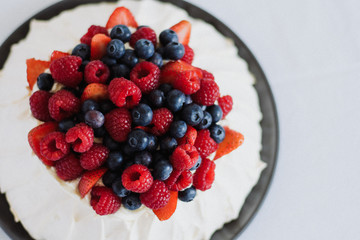 Tasty summer berry baiser pavlova cake with strawberries, raspberries and blueberries