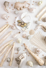 Plant based modern still life flat lay. Raw vegan ingredients set for cooking on white background: asparagus, mushrooms, eggs, noodles, cheese.