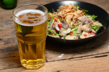 Glass of cold light beer with snacks