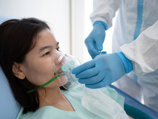Asian doctor wear PPE suit treat and use oxygen mask or emergency inhalation mask with coronavirus...