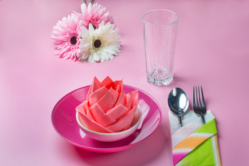 Table setting. On a pink background.