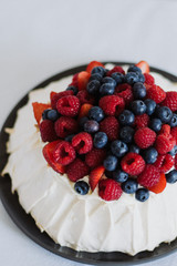Tasty summer berry baiser pavlova cake with strawberries, raspberries and blueberries