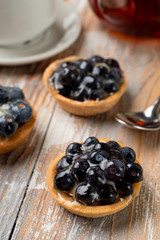 Close up of rustic homemade tartlets with custard and blueberry