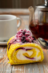 Sponge sweet roulade with whipped mascarpone cream and blueberry
