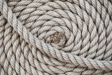 Braided thick rope tied in a skein. Hemp rope for decoration and design. Background from a fishing rope.