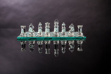 scacchi in vetro sopra scacchiera isolati su sfondo nero 