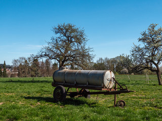Agricultural old rusty trailer with a water tank on it