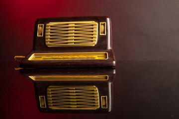 Antica radio su superficie riflettente , isolata su sfondo rosso 