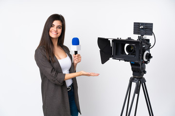 Reporter woman holding a microphone and reporting news over isolated white background holding copyspace imaginary on the palm