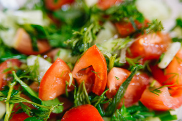 Spring or summer salad with fresh vegetables, tomatoes and cucumber in a bowl on a white background. Healthy raw food and vegetarian concept